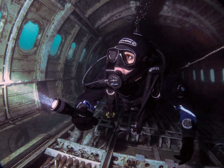 A diver inside a plane wreck in a flooded quarry. Quarry diving is an ideal way to train for more technically complex dives, including wreck dives.