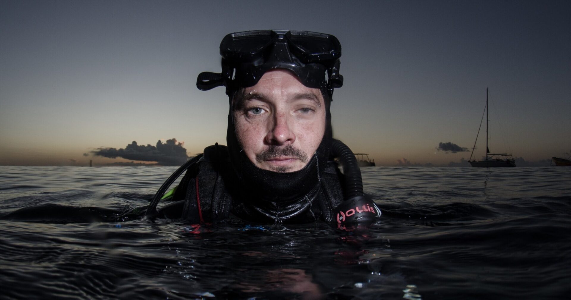 The author ready to submerge onto a shipwreck at twilight.