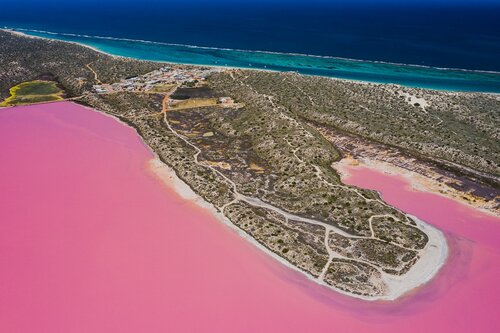 The lake contrasts beautifully with the shallow turquoise water of the reef and the deep blues of the Indian ocean beyond.