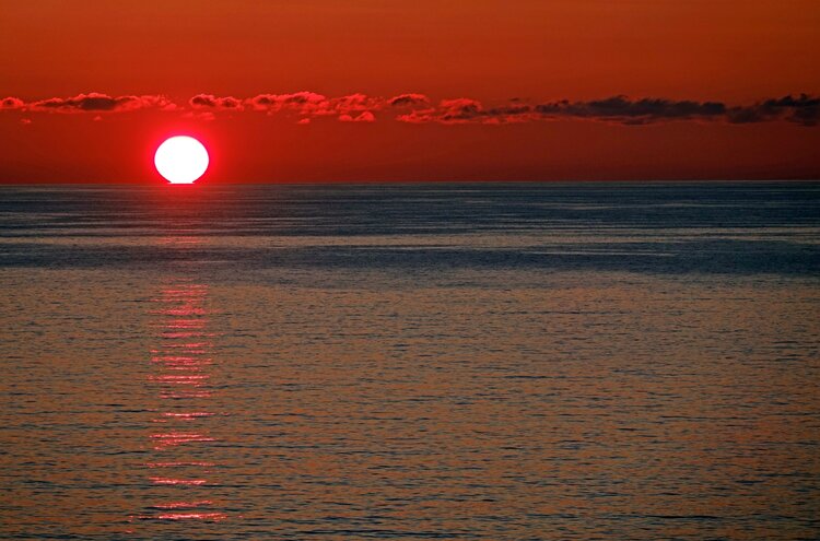The midsummer sun sinks into the Atlantic off Port Gaverne, North Cornwall.