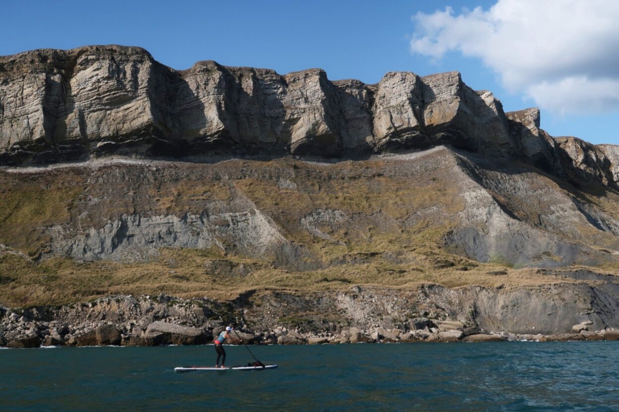Speeding beneath the spectacular precipice known as Gadd Cliff to the west of Kimmeridge Bay on Dorset's Jurassic Coast, powered up by a three knot tidal current and a Force 4 tailwind.