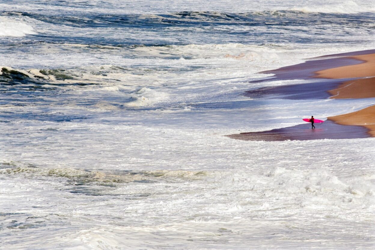Justine looking for a rip to paddle out between the huge waves of Praia do Norte, Nazaré © Hugo Silva / Red Bull