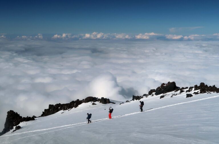 Three climbers descending towards Lenz Rocks after a successful summit bid.