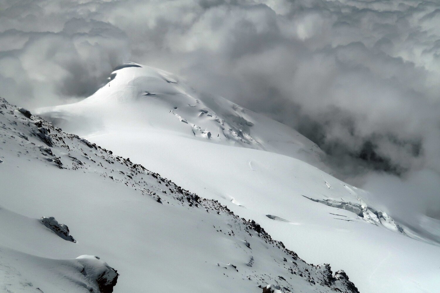 The view from the higher west summit of Mount Elbrus, looking down towards the slightly lower east summit.