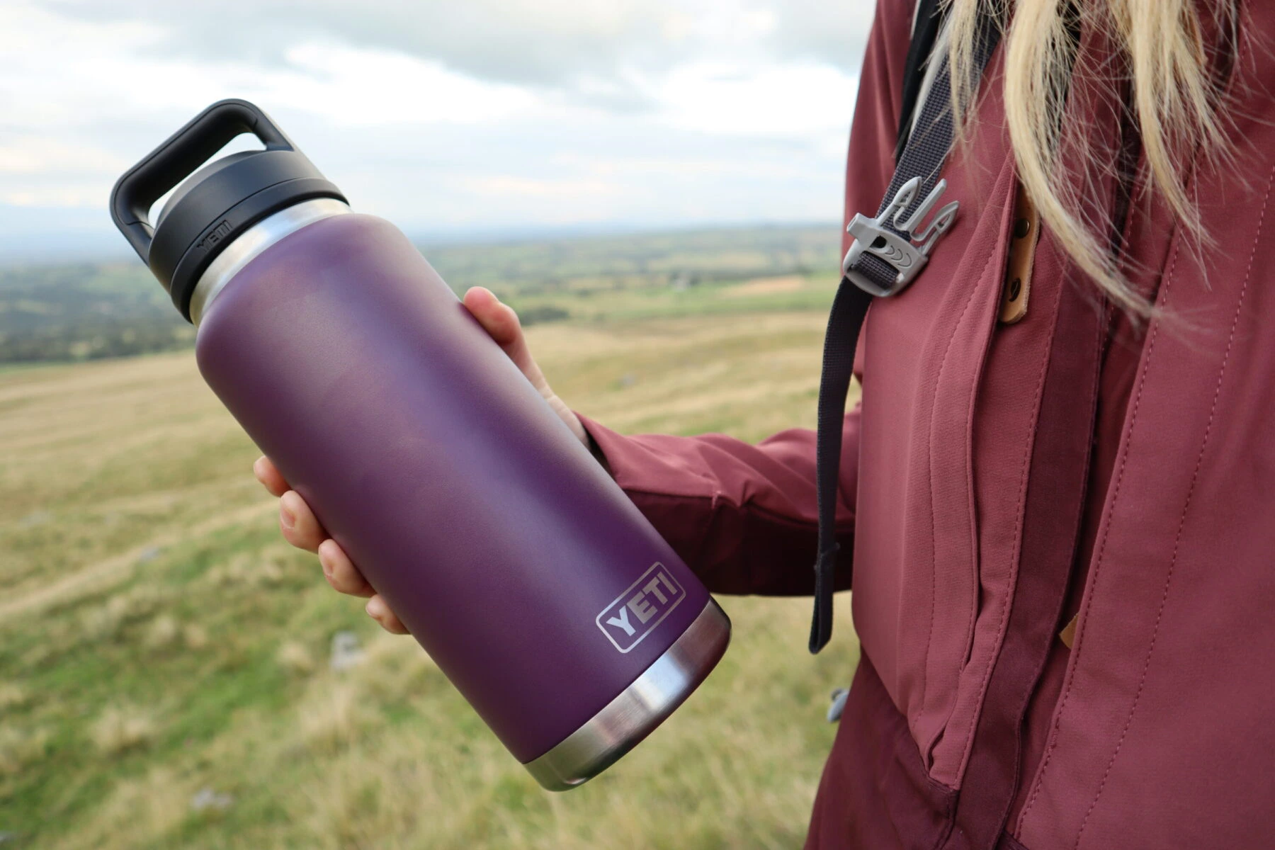 small steel thermos bottle and hot tea on a rock during cold